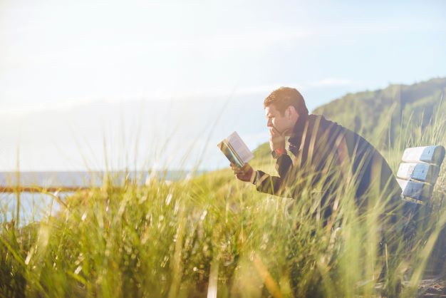 Man reading by a lake